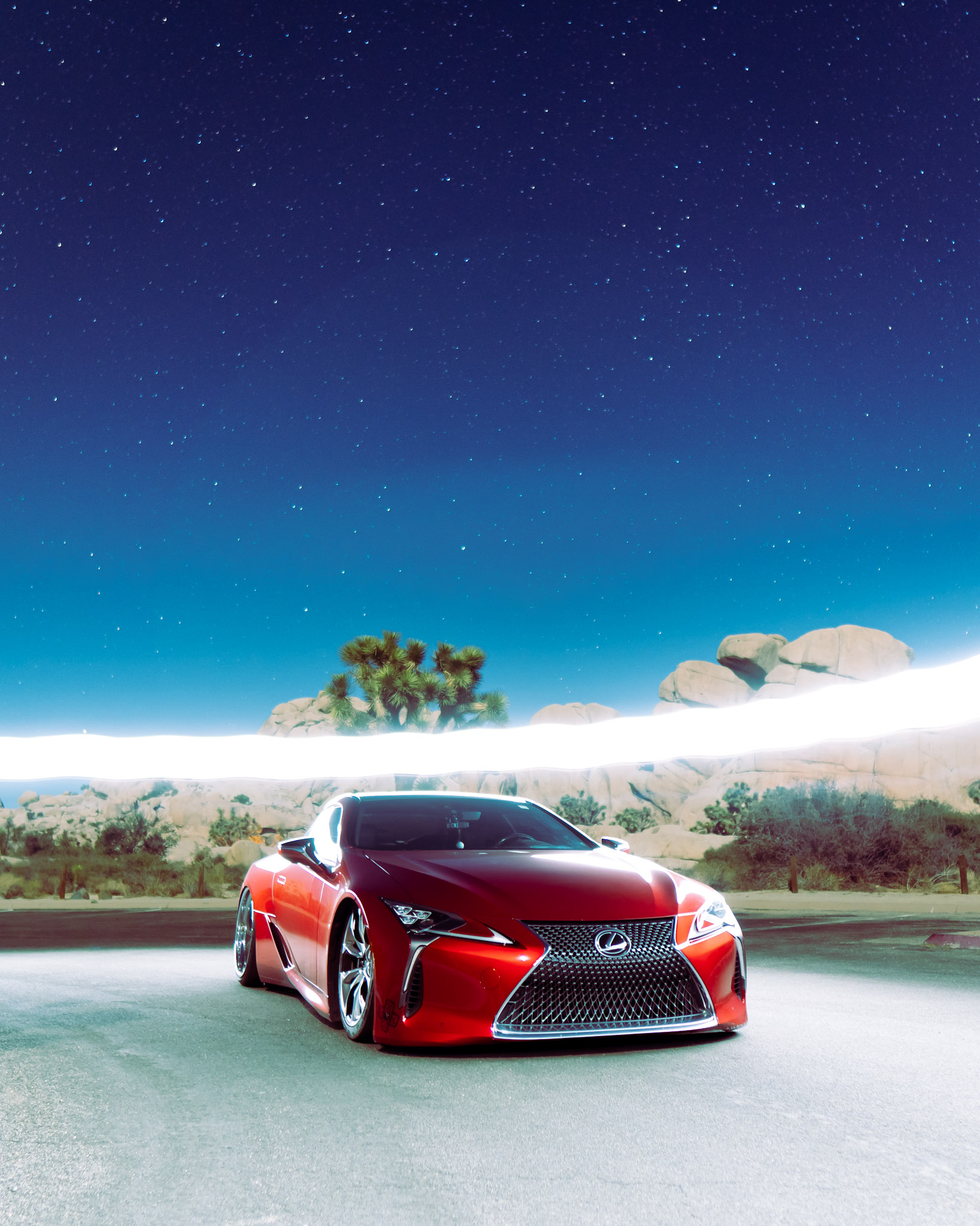 Red Lexus LC500 under a starry desert sky at Joshua Tree