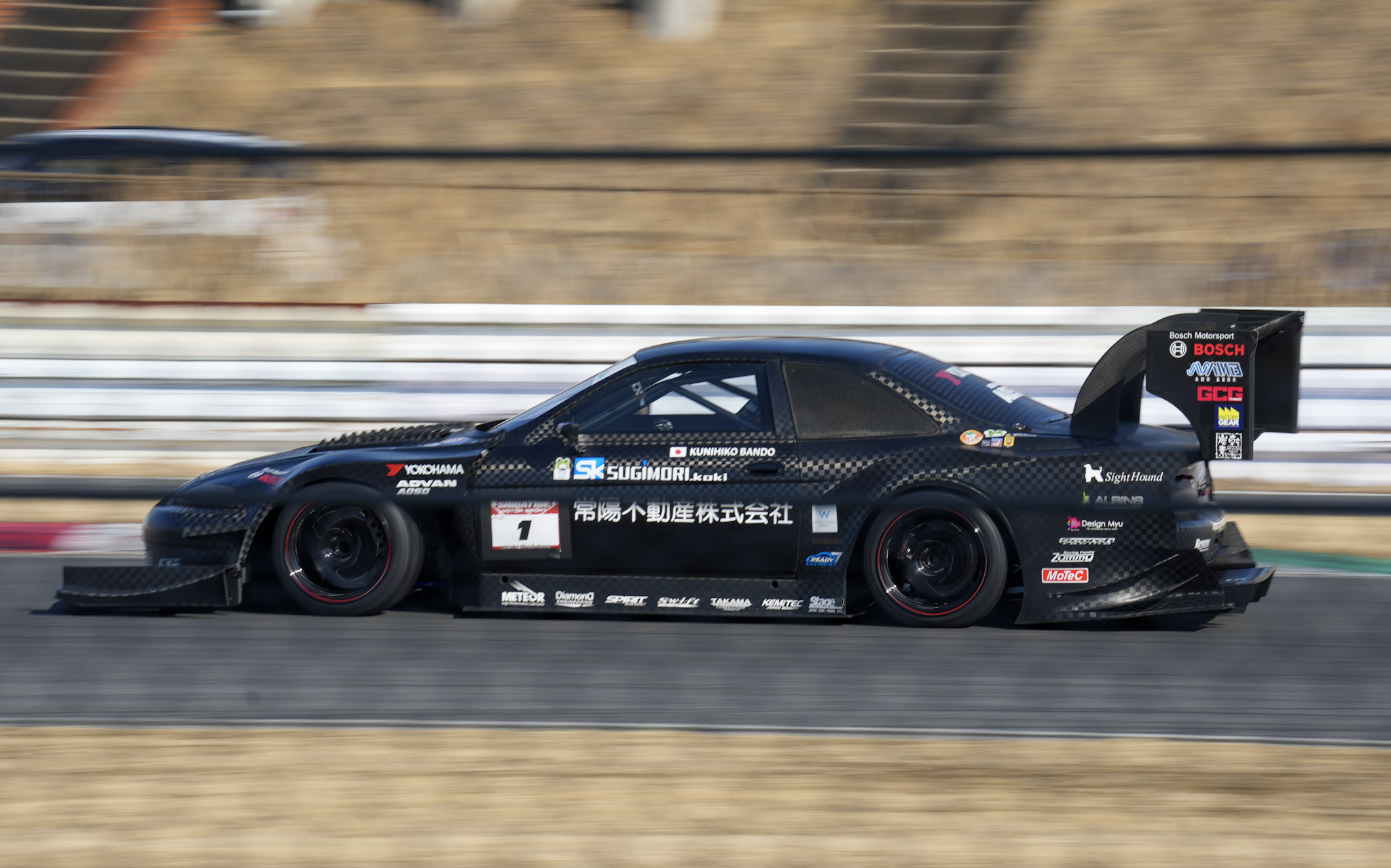 Full carbon fiber Nissan S14 time attack car in a panning shot at Tsukuba Circuit
